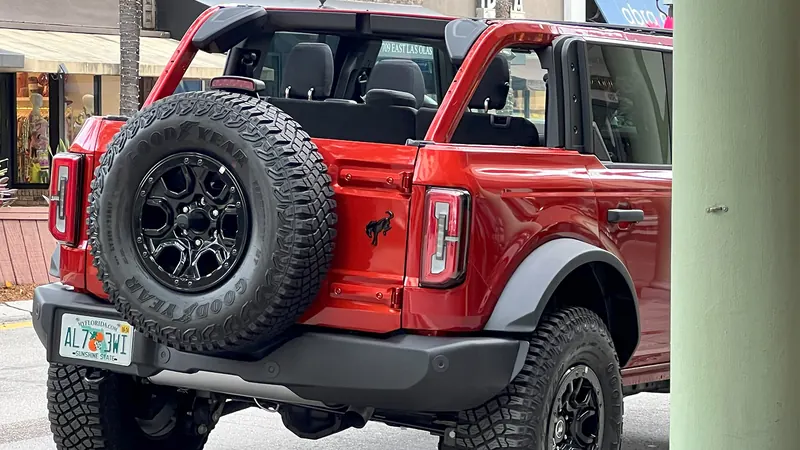 Red Ford Bronco parked by the beach