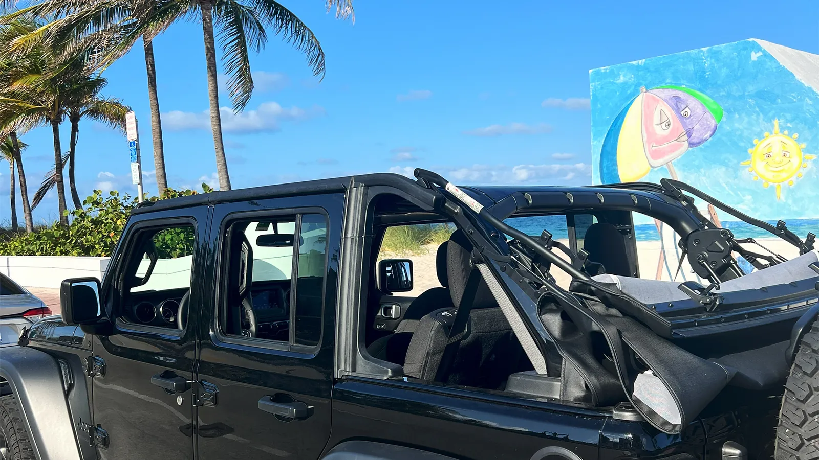 Jeep with the doors off parked by the beach