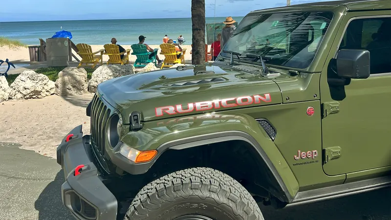 Green Jeep Rubicon on the beach
